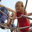 Children playing on Sherwood wooden playhouse rope structure.