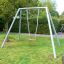 Silver Single Swing in a green garden with a red seat.