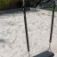 Silver Double Swing on a playground with a sandy surface