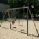 Silver Double Swing in a playground with a child in a seat swing and a regular swing