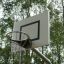 Outdoor basketball hoop in a park setting with trees in the background.