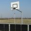 Outdoor basketball hoop with metal black fence in a sports area.