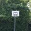 Basketball hoop from the 'Basket' product set up in a lush green park.