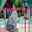 Children playing on an Orca steel structure climbing frame at a playground.