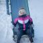 Butterfly playground slide with blue and green panels on snowy ground.