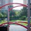 Spider steel structure in a playground with red and gray bars and ropes.