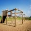 Kampinos wooden playhouse in a sunny playground.
