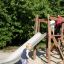 Children playing on Bergila wooden playground slide structure.
