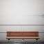 Steel construction bench on a wooden pier with foggy background.