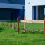 Wooden balance beam in a playground setting, part of Dolomiti outdoor play equipment.