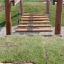 Wooden play bridge for kids by Dolomiti in a garden setting.