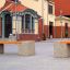 Concrete bench Vega in a courtyard with historic buildings in the background.