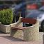 Outdoor bench Dona with red wooden seat and concrete sides placed between two planter boxes.