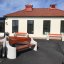 Outdoor benches Dona with wooden seating and concrete supports in front of a building.