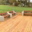 Wooden benches with concrete sides on a wooden deck in a park setting.