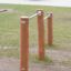 Outdoor fitness equipment Double Somersault Nature featuring wooden posts and metal bars.