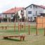 Outdoor playground equipment Double Somersault Nature in park setting with houses in background.