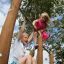 Children playing on the Double Somersault Nature outdoor playground equipment.