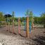 Outdoor playground equipment Triple Somersault Nature in a garden with trees and open sky.