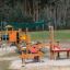 Outdoor playground with Sun Shade Square Atlantis (Metal) canopy and wooden play structures.