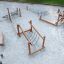 Sahara wooden playground climbing and balancing equipment on sand surface.