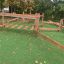Wooden playground equipment Sahara on green artificial grass.