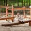 Sahara wooden playground balance beam and climbing ropes in forest setting
