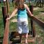 A child playing on the Sahara wooden bridge at a playground.
