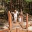 Wooden suspension bridge playground equipment Sahara with two children walking over.