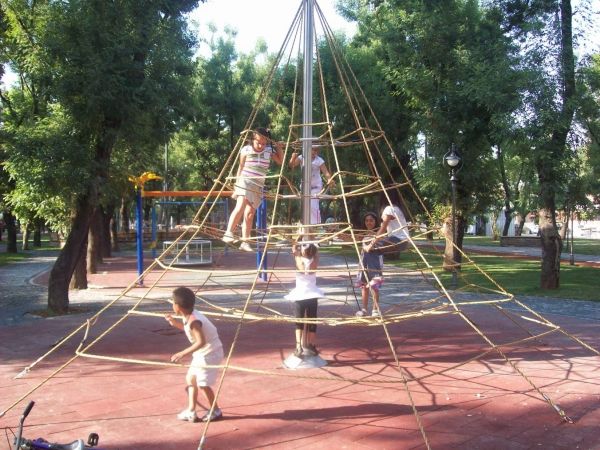 Children playing on Rubber Tiles 45 playground surface under a large rope climbing structure.