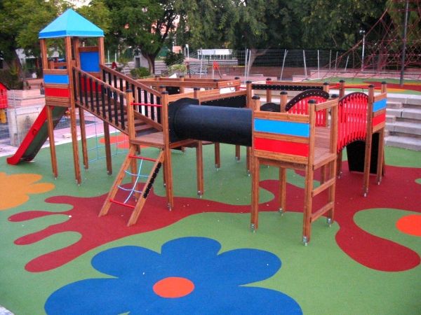 Wooden playground structure on colorful Wetpour 100 safety flooring.