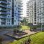 Willa Nature single playhouse on a playground in front of modern apartment buildings, with a slide a