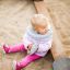 Small child playing in a sandbox next to the Willa Nature single playhouse.