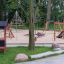 Playhouse Nature playground set with climbing structures and slides in a park.