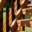 Wooden steps of the Country House Nature playground with black metal railings.