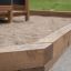 Wooden playhouse with slide in a sandbox in a garden