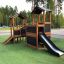 Wooden playhouse with slide for kids on playground.