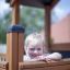 Child playing in Tower Nature wooden playhouse with slide.