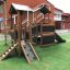 Wooden playhouse with slide in a playground.