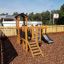 Fortress Nature playhouse with slide in a playground.
