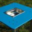Sand & Water Table with blue surface and stainless steel basin in the center, placed outdoors.