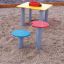 Table and chair in a children's playground with colorful seating.