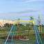 Playground featuring the Silver Single Swing (BNS) with a modern circular seat design.