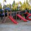 Mastodon castle with slide in a playground setting featuring multiple red slides and climbing struct