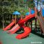 Mastodon castle with slide in a playground featuring multiple colorful slides.