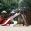 Mastodont playground climbing frame with slides and climbing wall on sandy ground