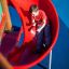 Boy sliding down the Mastodon castle with slide.