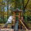 Six Angle Aztec wooden playground set with slides and climbing wall in the park.