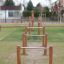 Outdoor playground equipment Single Somersault Nature with wooden posts and metal bars.