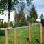 Outdoor playground equipment Single Somersault Nature with wooden posts and metal bar on grass.